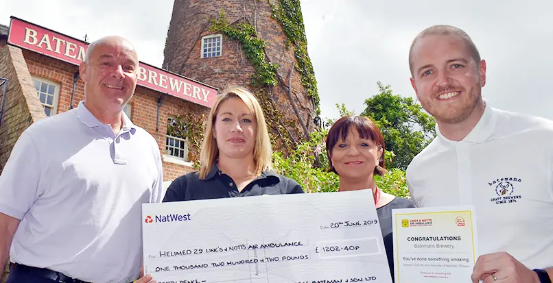 Batemans staff handing over a cheque to Lincs & Notts Air Ambulance