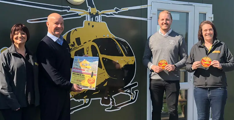 Team members from Batemans and the Lincs & Notts Air Ambulance promote Batemans' charity beer infront of an Ambucopter wall mural