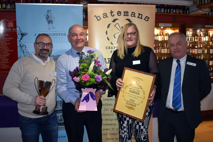 Business Owners of the Plough pub in Nettlleham picking up the Batemans Best Publican Award