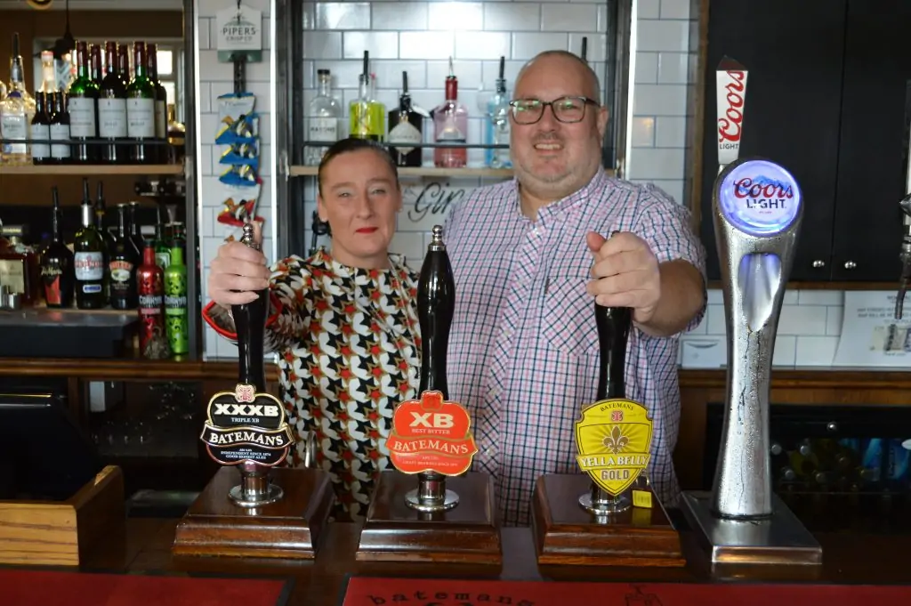 New Business Owners at the Woolpack pub stood behind the bar.