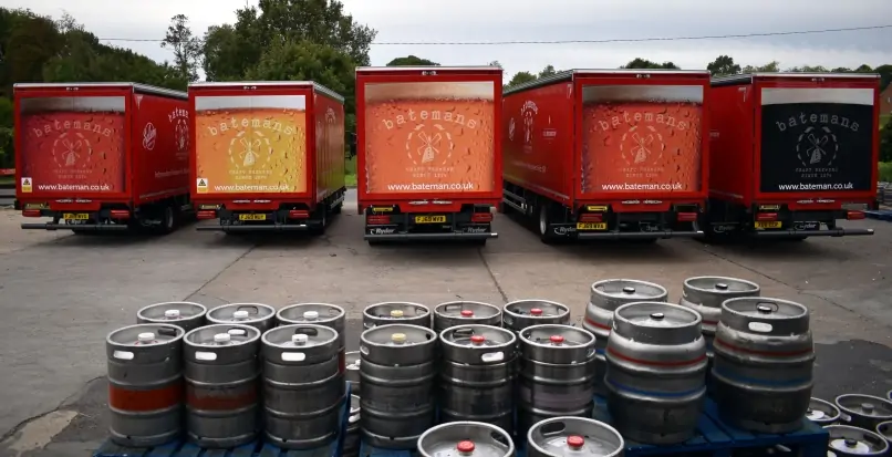 Batemans lorries parked at the Brewery in front of beer barrels