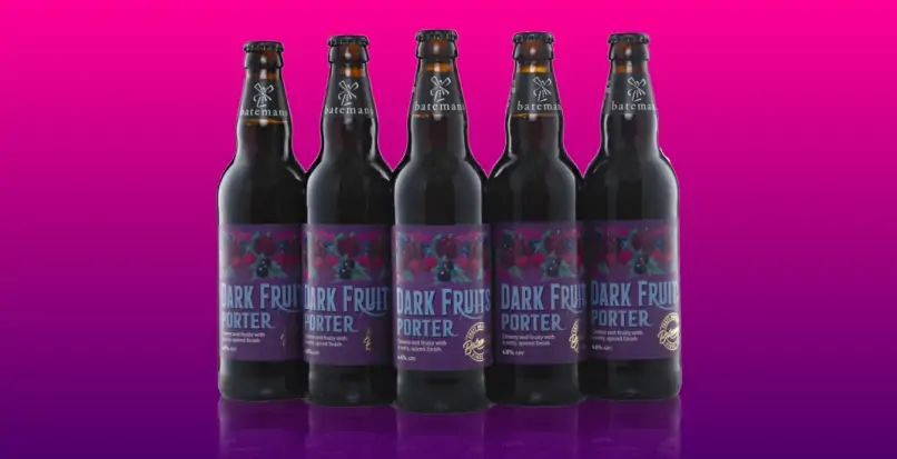 Bottles of Batemans Dark Fruit Porter on a pink and purple gradient background