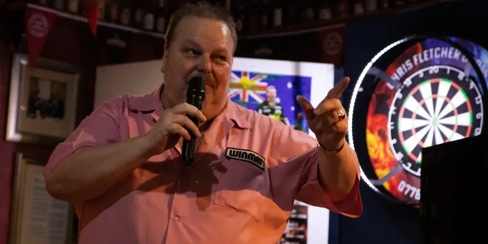 Peter Manley Pro Darts Player at the Batemans 150th anniversary celebrations darts competition talking on a microphone.