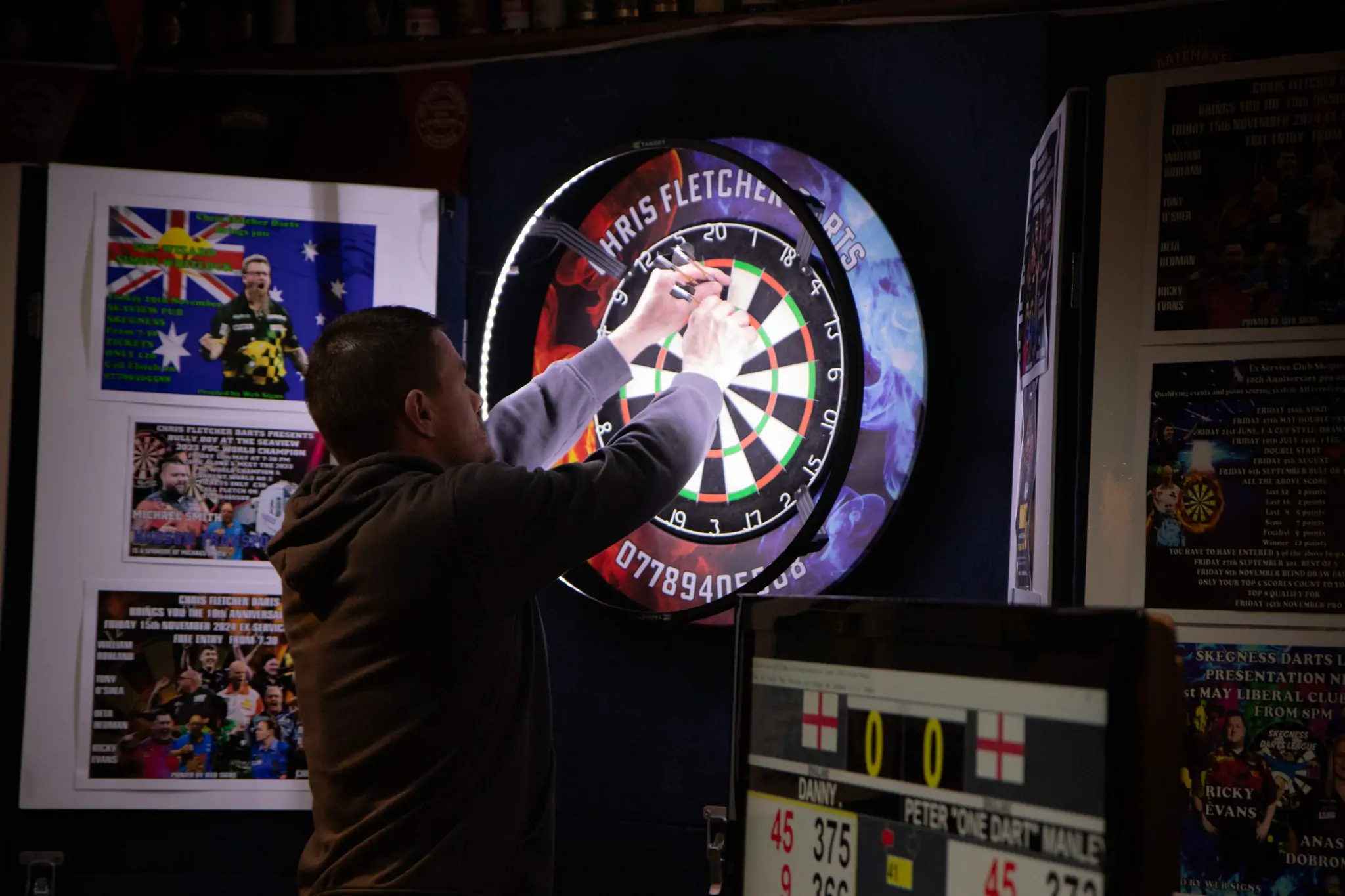Peter Manley Pro Darts Player at the Batemans 150th anniversary celebrations darts with one of the competitors.