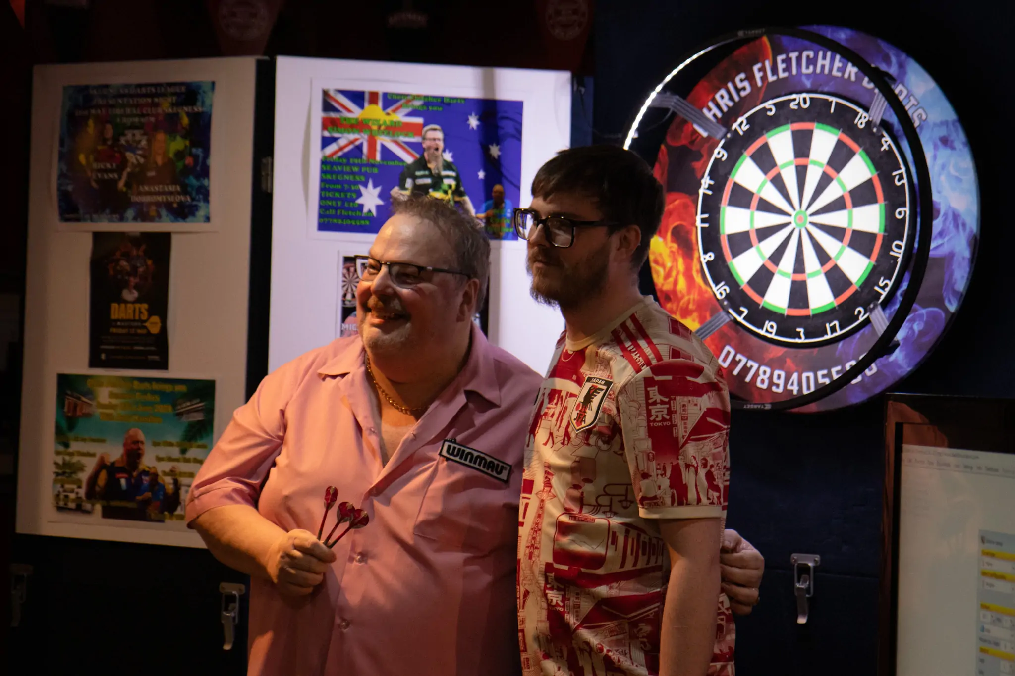 Peter Manley Pro Darts Player at the Batemans 150th anniversary celebrations darts with one of the competitors.