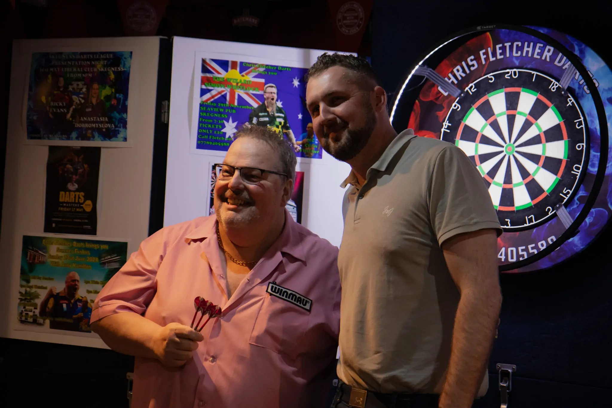 Peter Manley Pro Darts Player at the Batemans 150th anniversary celebrations darts with one of the competitors.