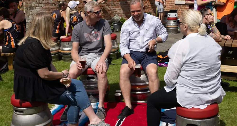 Five Generations Charity Fun Run - Beer Garden people sat on beer barrels drinking and laughing