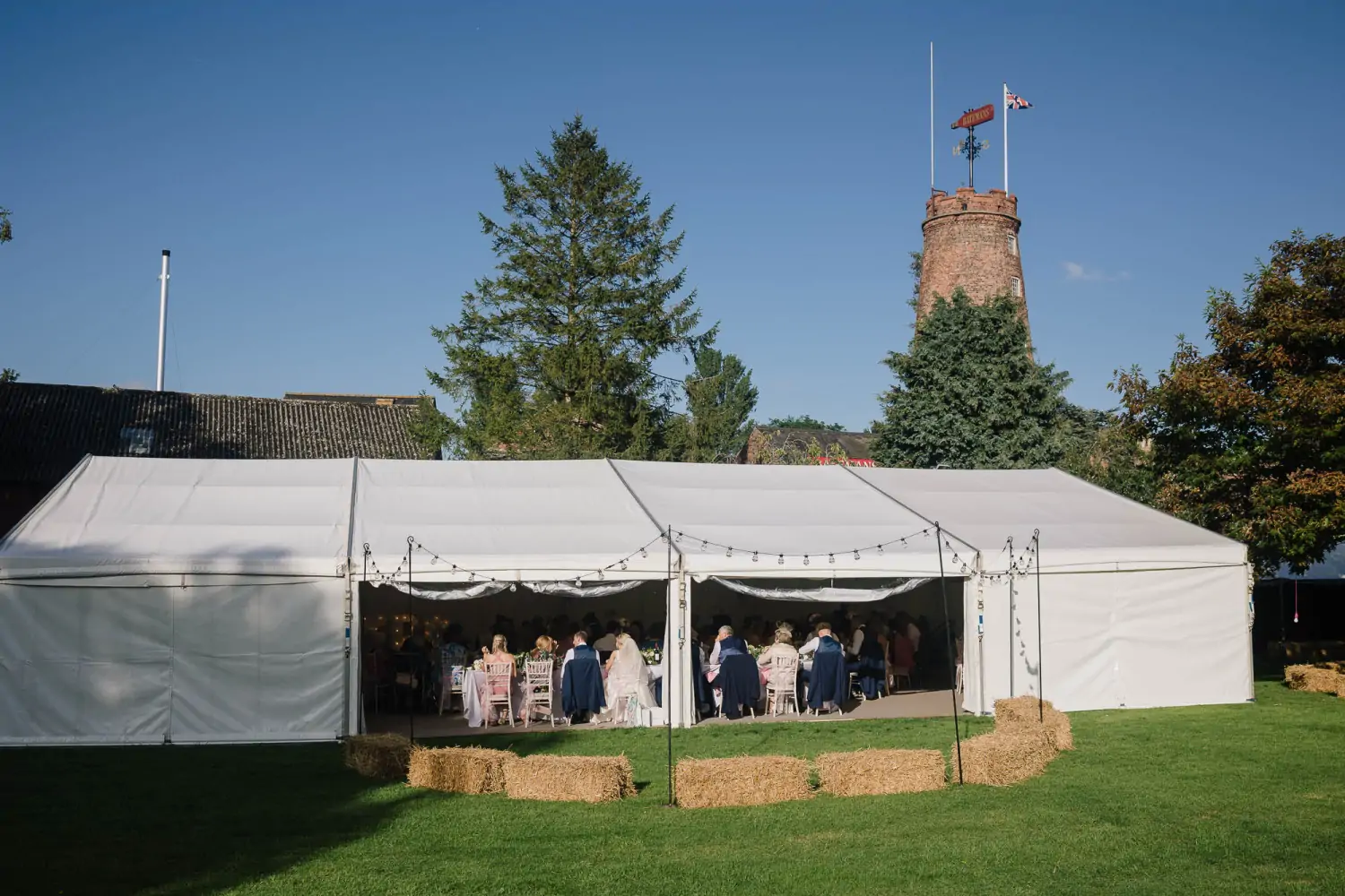 Batemans Wedding - Wedding marquee on Batemans grounds with straw hay bales for seating